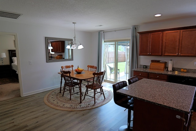 dining space featuring visible vents, wood finished floors, recessed lighting, a textured ceiling, and a chandelier