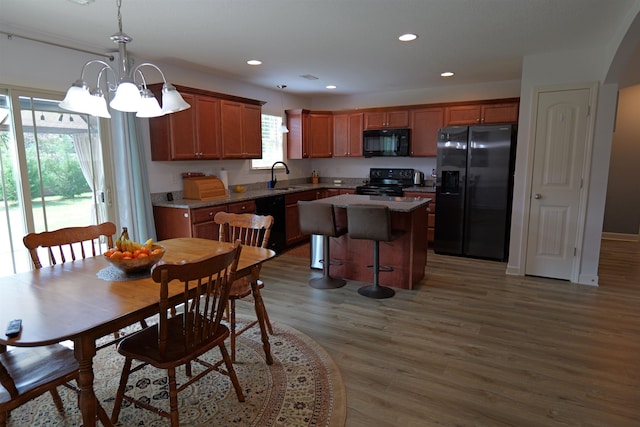 dining room with recessed lighting, wood finished floors, and a notable chandelier