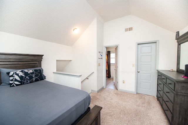 bedroom with baseboards, visible vents, light colored carpet, and lofted ceiling