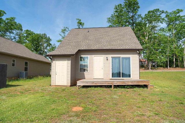 rear view of property with a wooden deck, a shingled roof, a yard, and cooling unit