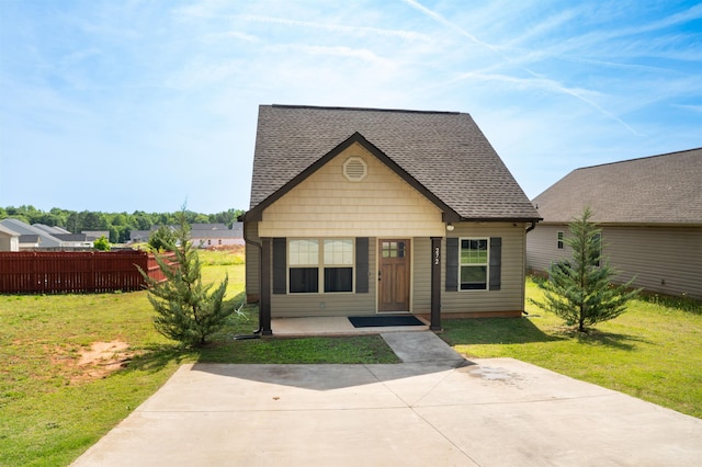bungalow with roof with shingles, fence, and a front yard
