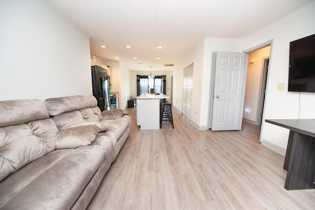 living room with recessed lighting, baseboards, visible vents, and light wood-style floors