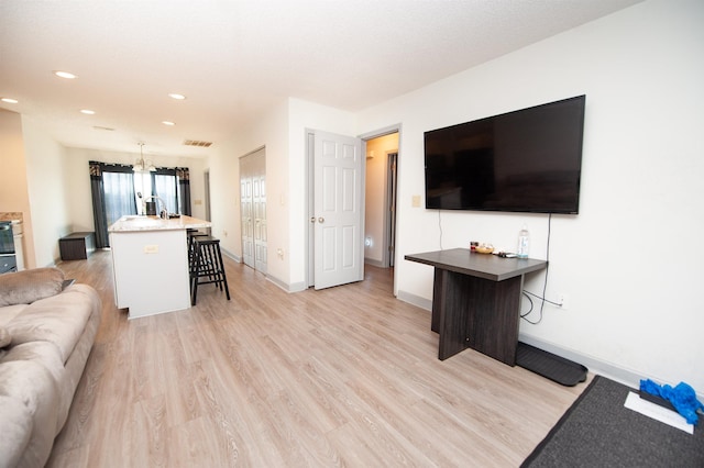 living room with visible vents, light wood-type flooring, baseboards, a notable chandelier, and recessed lighting