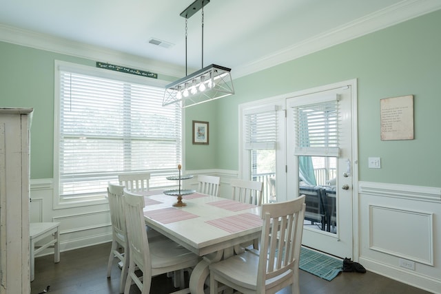 dining area featuring a decorative wall, ornamental molding, wainscoting, and visible vents