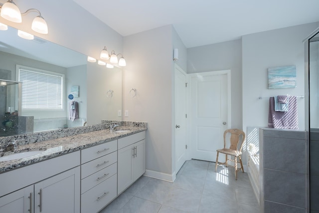 bathroom featuring a sink, tile patterned floors, a stall shower, and double vanity