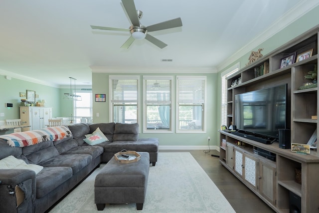 living room featuring visible vents, ornamental molding, dark wood-style flooring, and ceiling fan