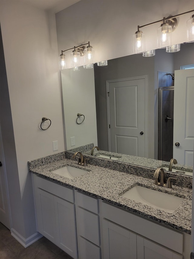 full bathroom with double vanity, a tile shower, a sink, and tile patterned flooring