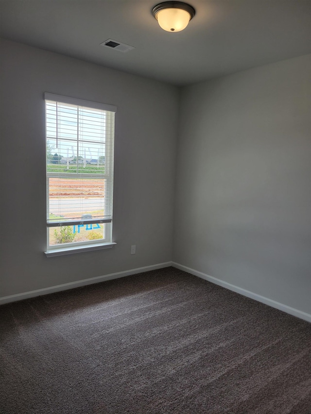 spare room with visible vents, carpet, and baseboards
