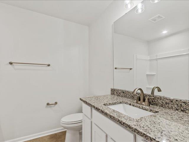 bathroom featuring vanity, tile patterned flooring, visible vents, toilet, and baseboards