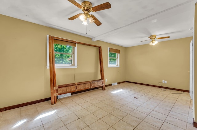 unfurnished room with baseboards, ceiling fan, and light tile patterned floors
