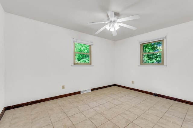 spare room featuring baseboards, a ceiling fan, and visible vents
