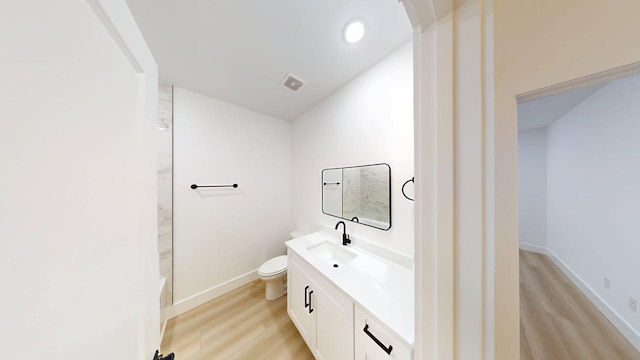 full bathroom featuring vanity, toilet, wood finished floors, and visible vents