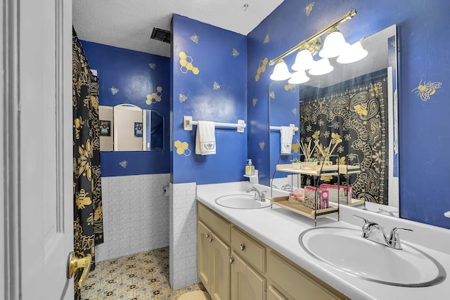 full bathroom with double vanity, a sink, and wainscoting