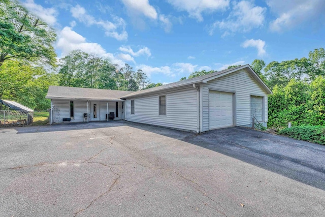 ranch-style home with a detached garage and a porch