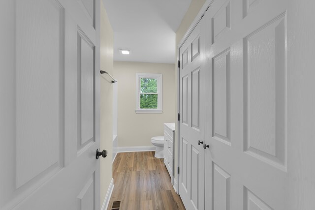 full bath featuring visible vents, wood finished floors, baseboards, toilet, and  shower combination