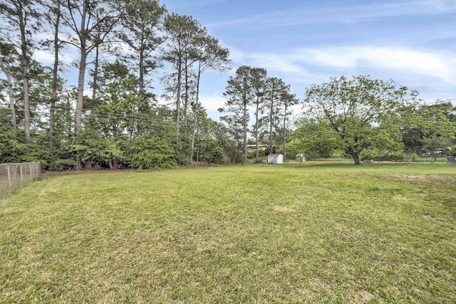 view of yard featuring fence and a shed