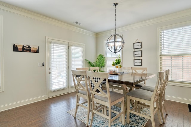 dining space with visible vents, dark wood finished floors, baseboards, an inviting chandelier, and ornamental molding