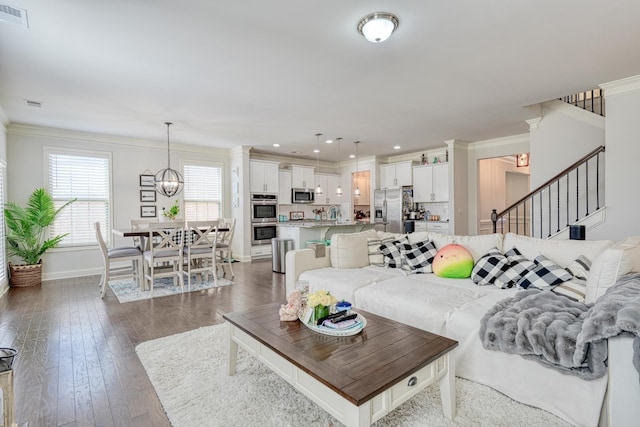 living room with visible vents, crown molding, dark wood finished floors, stairway, and baseboards