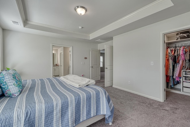 carpeted bedroom with crown molding, a tray ceiling, a spacious closet, and visible vents