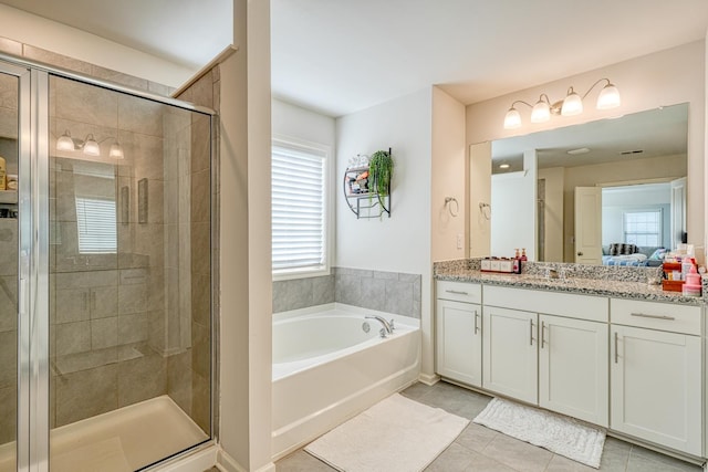 bathroom featuring tile patterned floors, a shower stall, a bath, and vanity