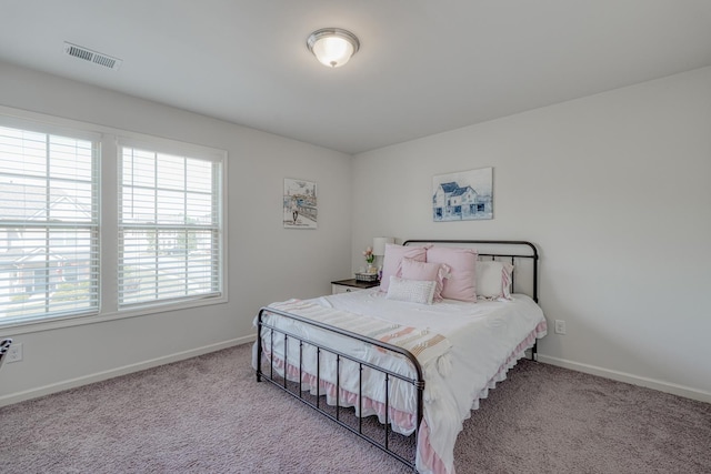 bedroom featuring carpet floors, multiple windows, and visible vents