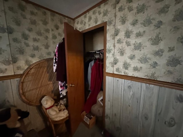 bedroom with crown molding and wallpapered walls