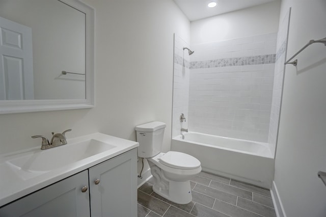 bathroom featuring vanity, toilet, baseboards, washtub / shower combination, and recessed lighting