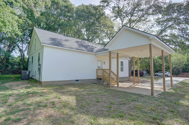 exterior space featuring roof with shingles, central AC unit, a lawn, and crawl space