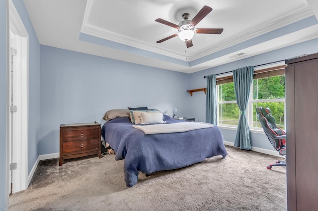 carpeted bedroom with crown molding, a tray ceiling, visible vents, and baseboards