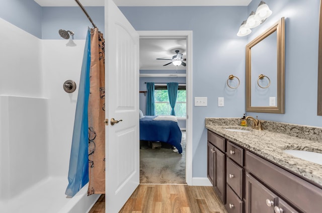 bathroom with a sink, double vanity, wood finished floors, and a shower with shower curtain