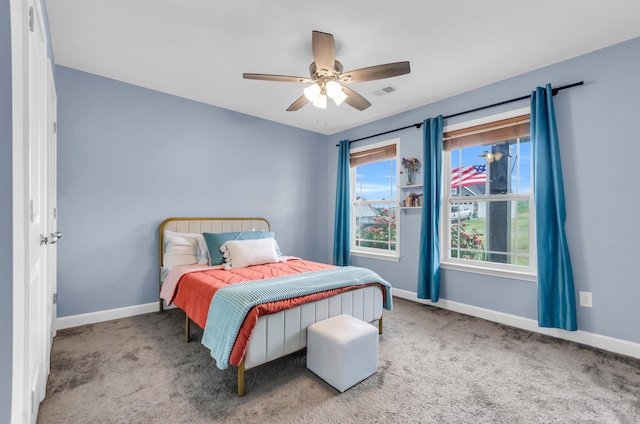 carpeted bedroom featuring baseboards, ceiling fan, and visible vents