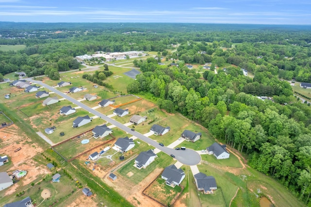 birds eye view of property featuring a view of trees