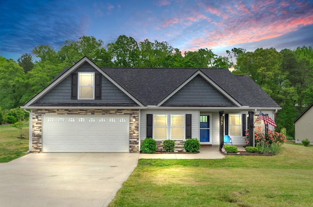 craftsman-style home with a garage, a yard, stone siding, and concrete driveway