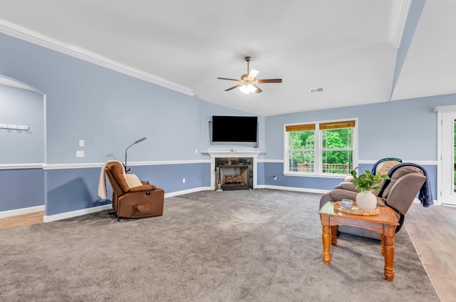 carpeted living room featuring visible vents, baseboards, a tile fireplace, a ceiling fan, and vaulted ceiling