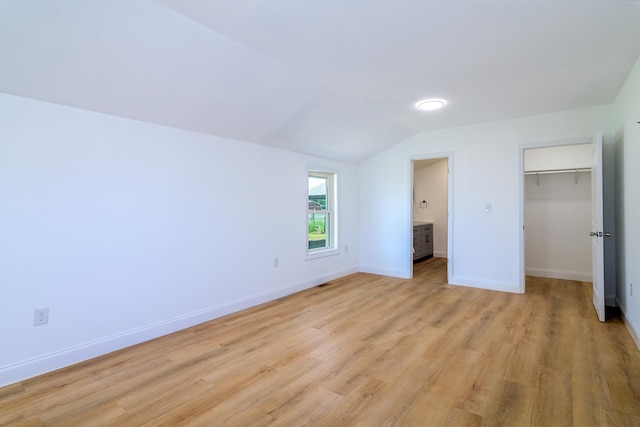583 Berry, Boiling Springs, SC 29316 - unfurnished bedroom with a walk in closet, light wood finished floors, baseboards, vaulted ceiling, and a closet