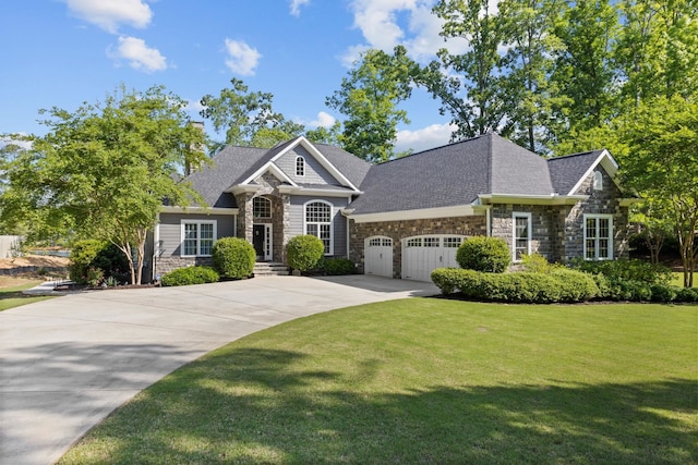 craftsman-style home featuring a garage, a front lawn, concrete driveway, a shingled roof, and stone siding