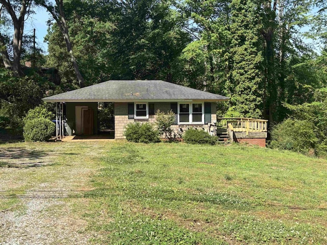ranch-style home with a front lawn, a wooden deck, and a carport