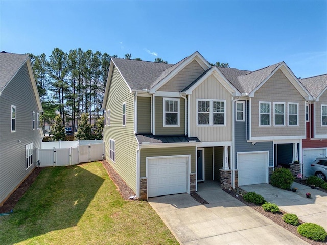 townhome / multi-family property with a garage, stone siding, a gate, board and batten siding, and driveway