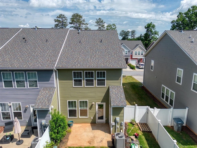 back of property with a patio, central AC unit, a fenced backyard, and a shingled roof