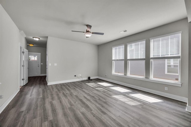 unfurnished living room featuring baseboards, visible vents, ceiling fan, and wood finished floors
