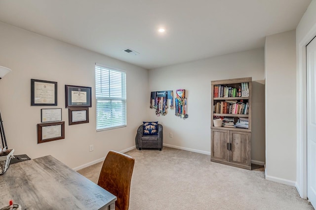 office with visible vents, baseboards, and light carpet