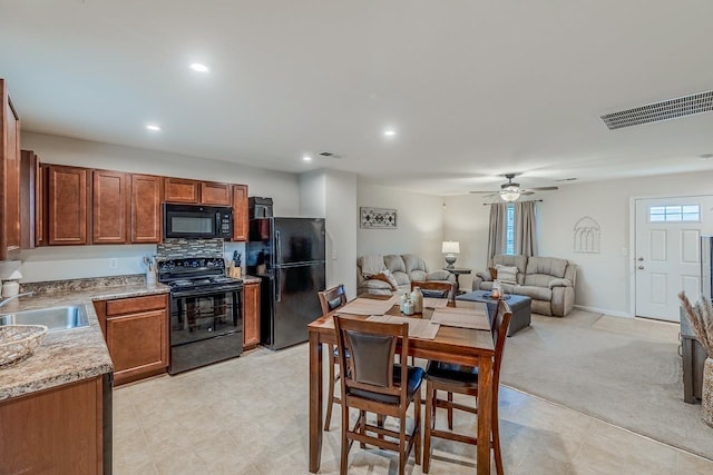 kitchen with a ceiling fan, visible vents, a sink, and black appliances