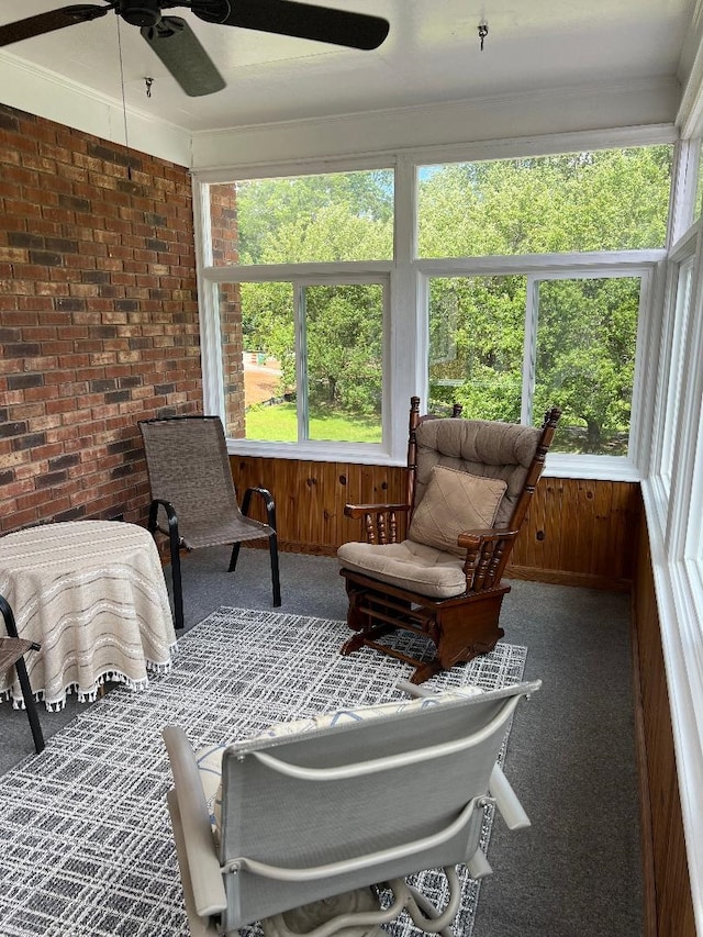 sunroom / solarium featuring a healthy amount of sunlight, crown molding, and carpet