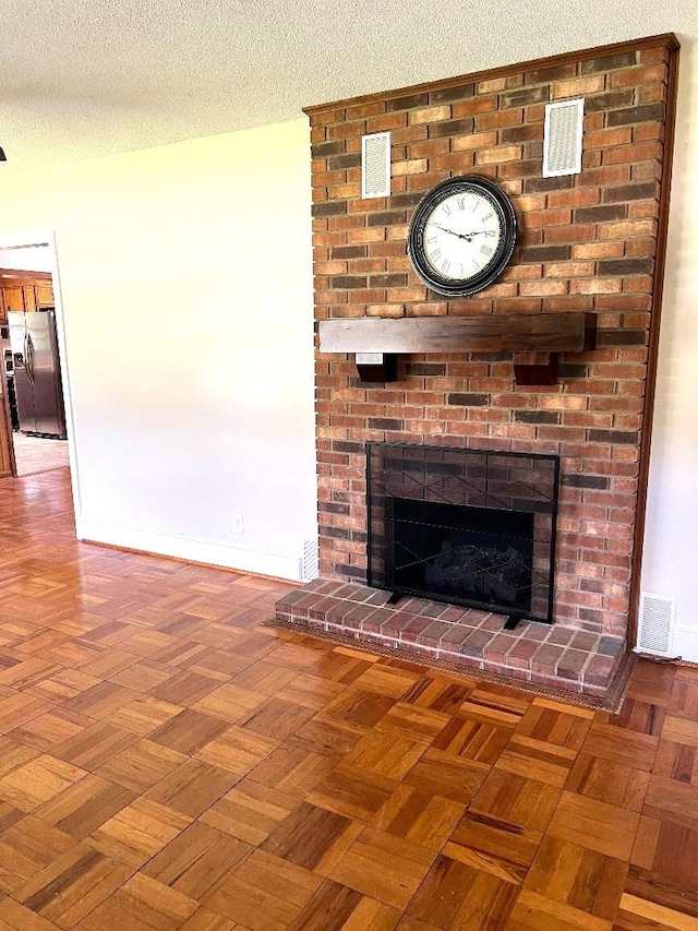 details featuring a brick fireplace, baseboards, visible vents, and stainless steel fridge