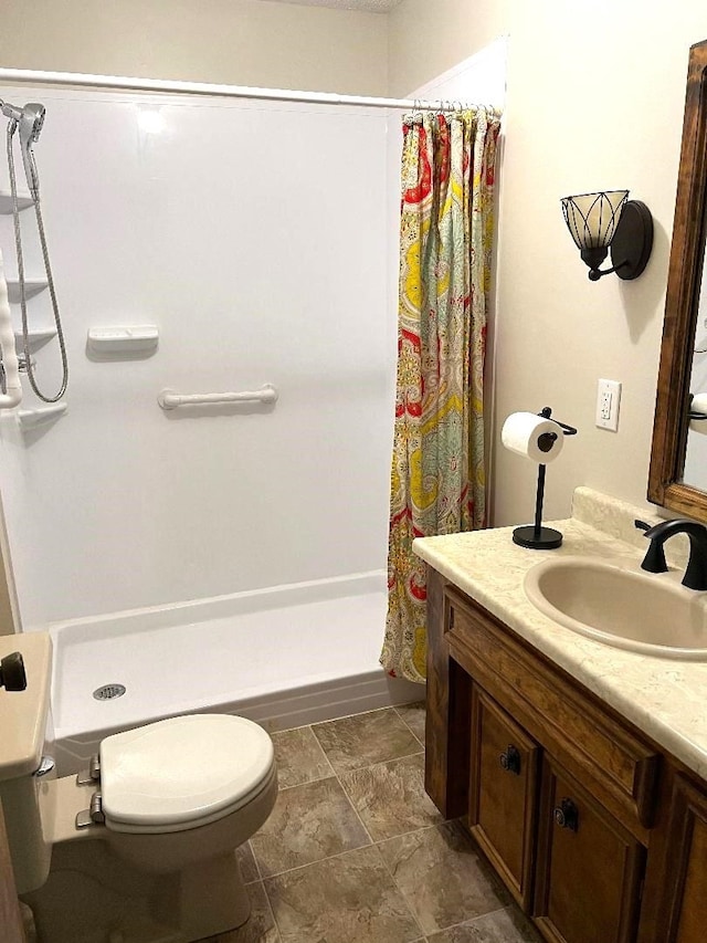 bathroom with vanity, a stall shower, and toilet