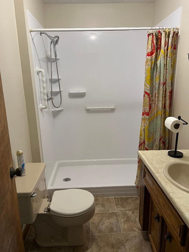full bath with vanity, a shower stall, and toilet