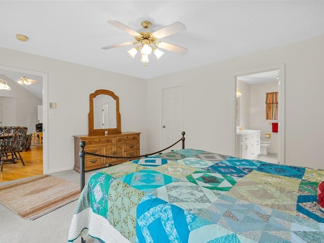 bedroom with a ceiling fan, baseboards, ensuite bath, and light colored carpet