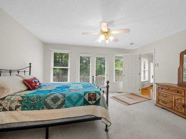 bedroom featuring carpet, a textured ceiling, and a ceiling fan