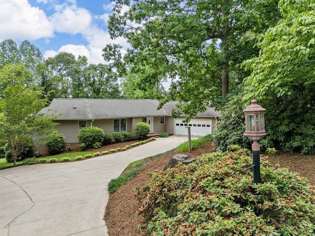 single story home featuring concrete driveway and a garage