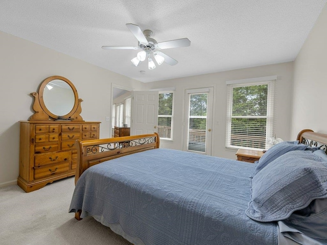 bedroom with light colored carpet, a textured ceiling, a ceiling fan, and access to exterior